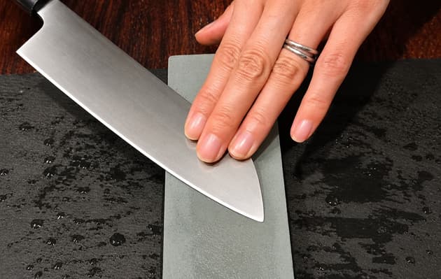 The Whetstone and the Edge Japanese knife held at 45 degrees across a whetstone, viewed from above