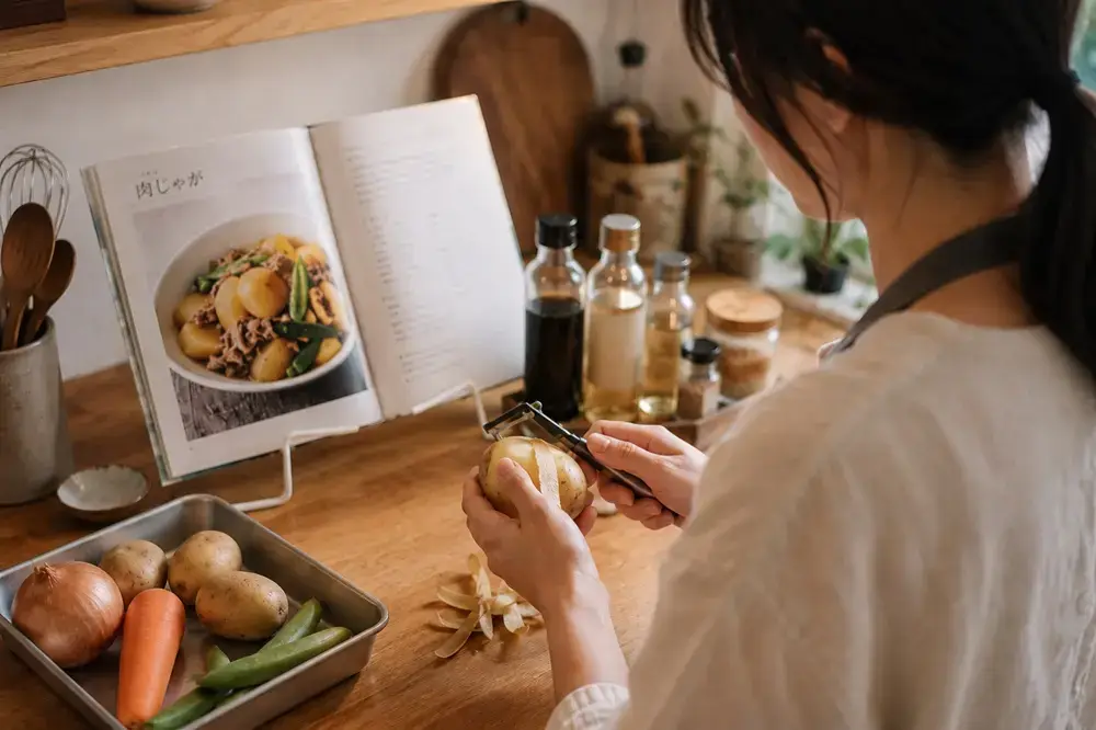 Japanese Pantry Essentials: 6 Seasonings for Everyday Japanese Recipes Cooking nikujaga at home while following a Japanese recipe book