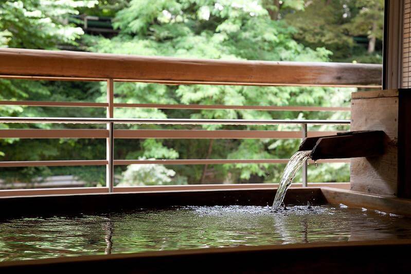 The Onsen Paradox: Why Japanese People Aren’t Embarrassed to Bathe Naked Together Okutone Hachiyu outdoor onsen bath at Minakami Minekami ryokan, steam rising over still water