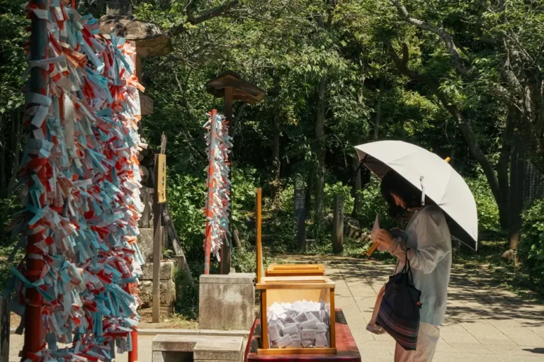 A woman buying omikuji at a shrine in Japan