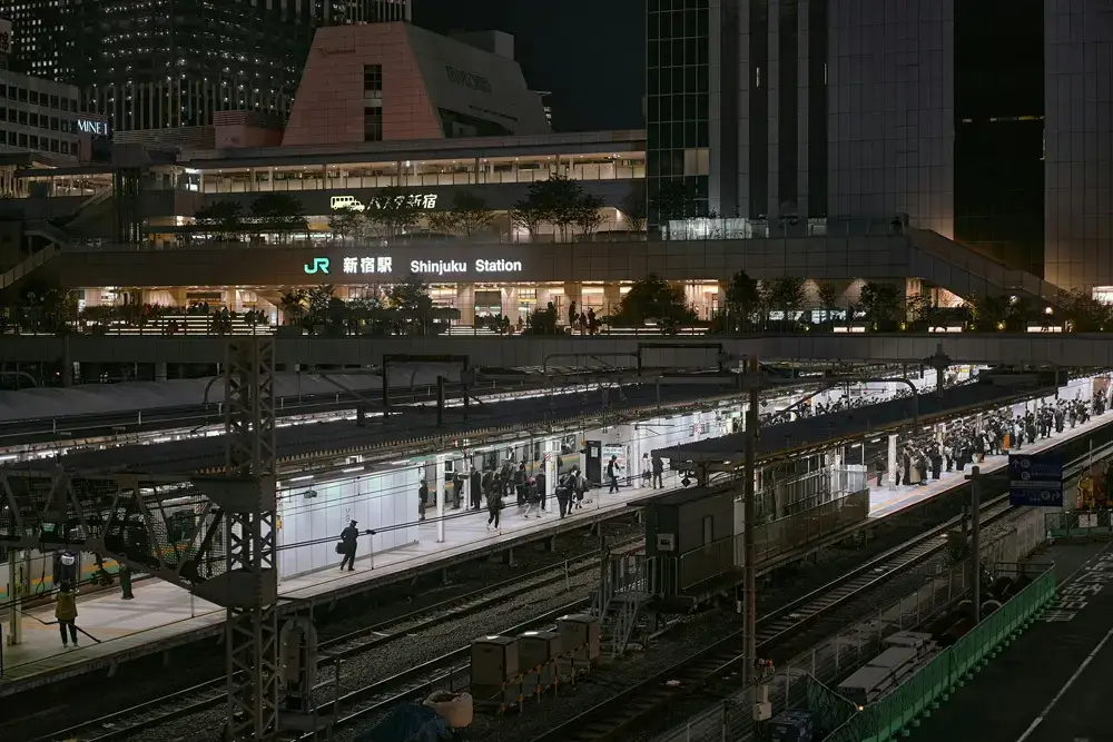 JR Hakata Station platforms with waiting passengers at night