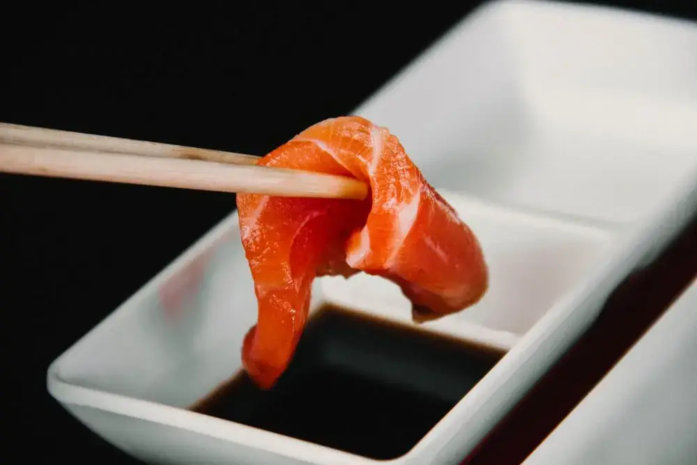 Japanese Pantry Essentials: 6 Seasonings for Everyday Japanese Recipes Sashimi with soy sauce for dipping on a wooden chopstick rest