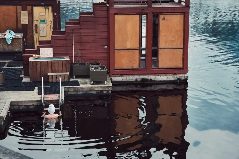 Why Torture Yourself? Why Japan’s Businesspeople Became Obsessed With Sauna A person entering cold water from a wooden structure
