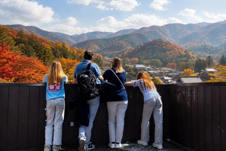 Family looking over autumn coloured mountains in Japan