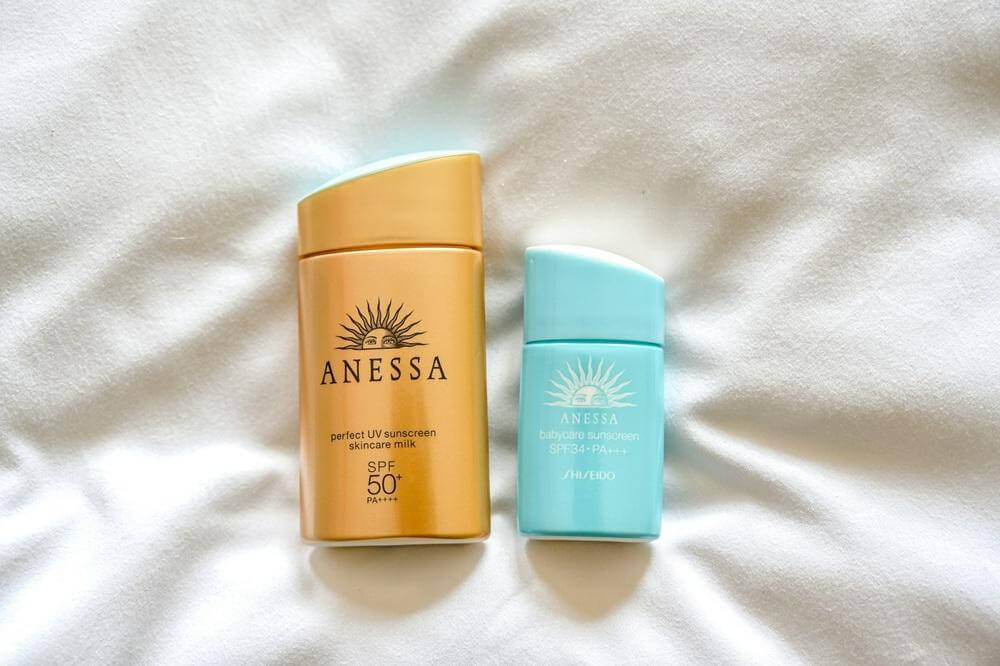 Two sun care products with blue-green and yellow labels